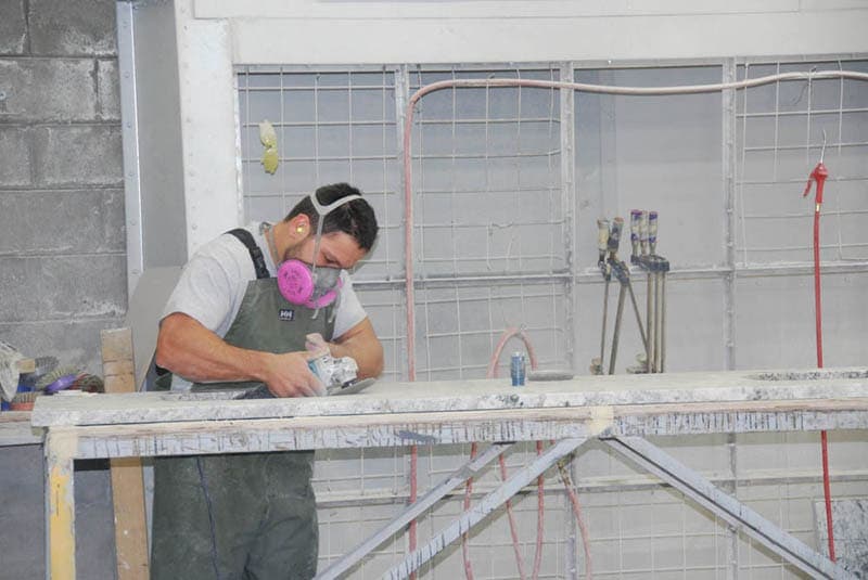 Fabricator hand-finishing a stone edge
