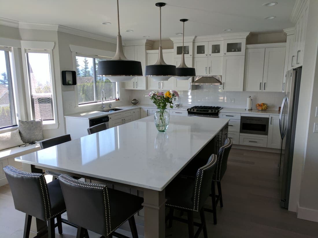 White quartz waterfall island with pendant lighting